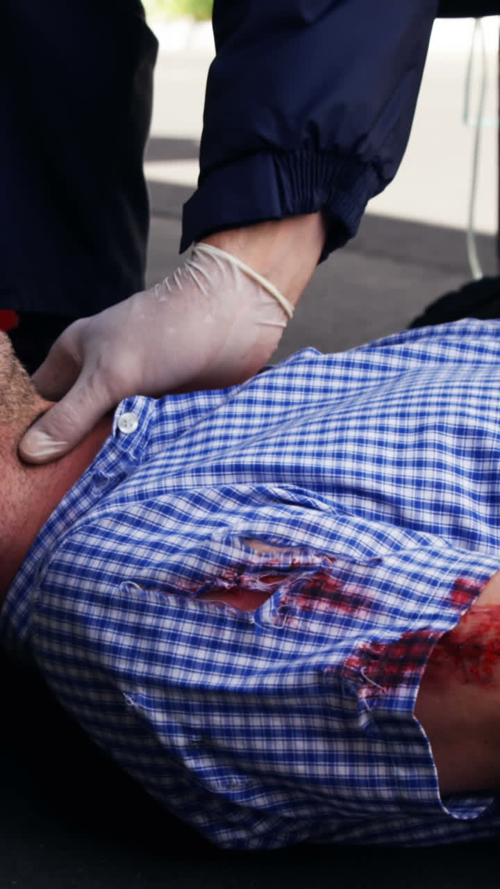 técnico médico de emergencia tomando el pulso del hombre herido