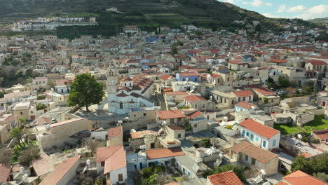 Overlooking-the-dense-and-historic-rooftops-of-Lefkara,-essence-of-the-village-with-its-stone-houses,-narrow-streets,-and-the-prominent-church-standing-as-a-focal-point-amidst-the-terracotta-roofs