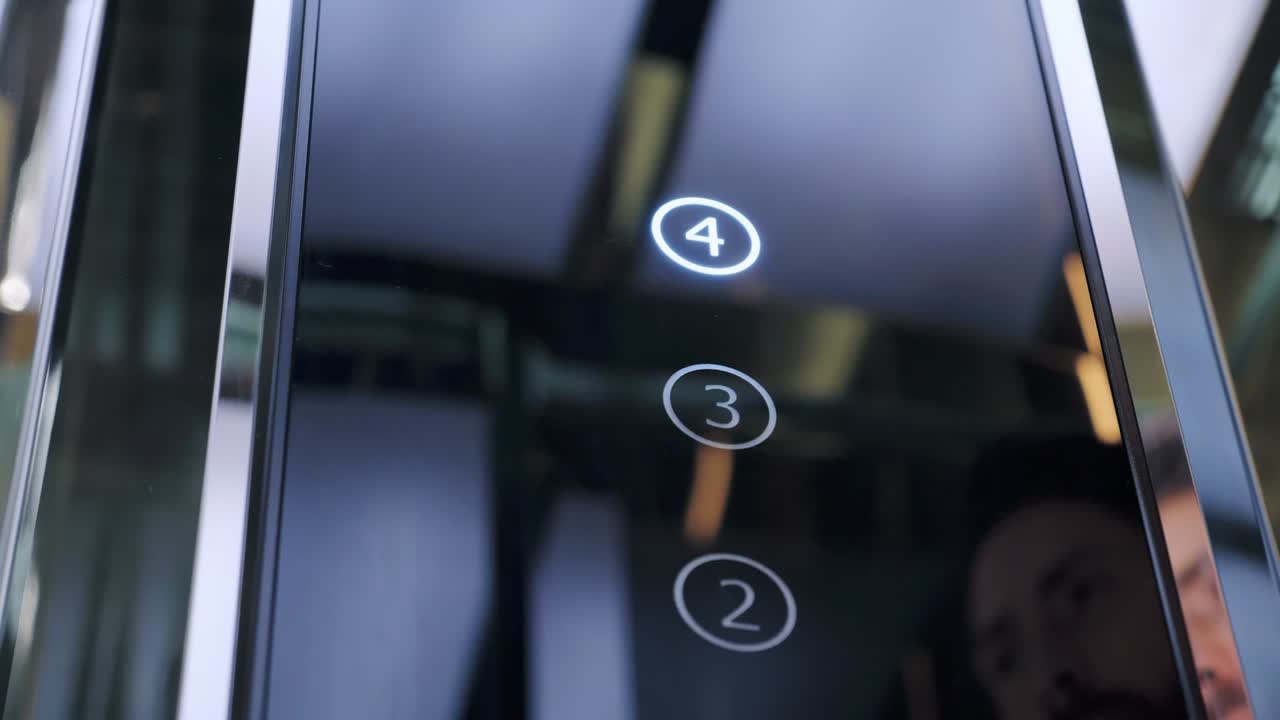 Man's hand presses a button on the modern glass elevator. Lift moving up to the office. Male Hand Pushing Elevator Car Button in Office Center Or Hotel. Technology, progress, growth success concept.