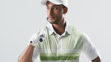 young biracial man dressed in golf attire poses confidently