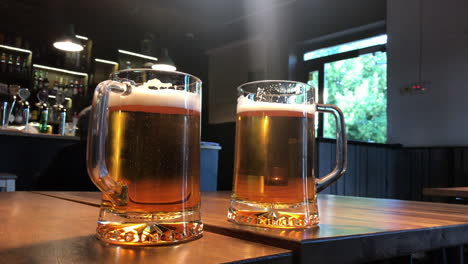 two mugs of beer on table in a bar