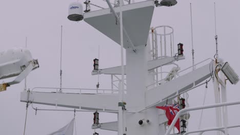 ferry mast with british flag flying and radar instrument spinning with radio transmitters for communication 4k