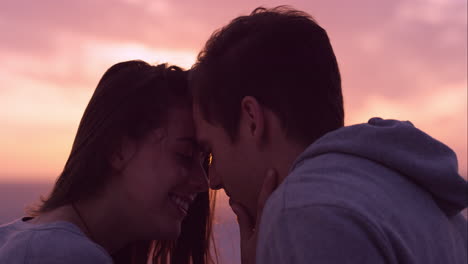 feliz pareja enamorada besándose al atardecer mostrando intimidad emocional tocándose abrazándose y acurrucándose