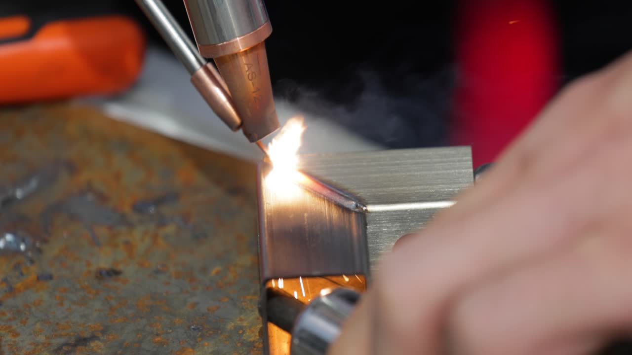 Macchina per saldatura laser con saldatore a pistola. La saldatura laser è mostrata in primo piano