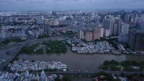 Ho-Chi-Minh-City,-Vietnam-aerial-shot-during-day-time-with-boats-on-canal-and-road-traffic-over-bridge-showing-old-and-new-architecture