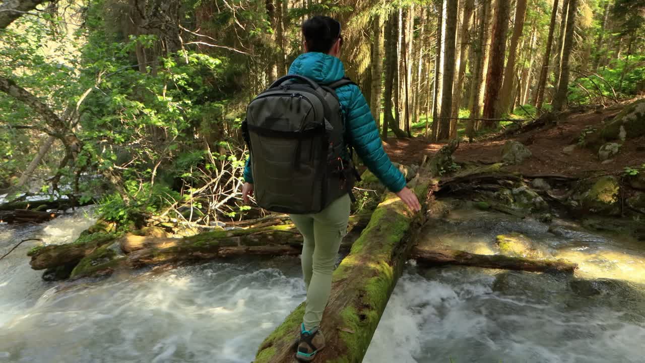 mujer caminando con una mochila de senderismo en el bosque verde de primavera