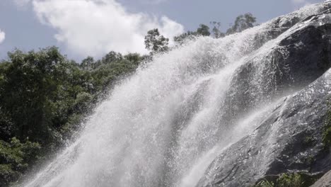 Slow-motion-low-angle-view-up-to-clean-crisp-water-flowing-off-rock-formation-boulders