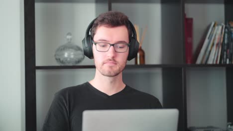 young modern caucasian man home office worker college student learns laptop table at home