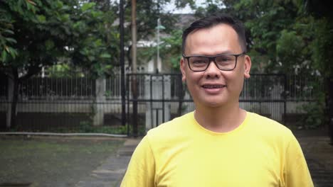 man smiling confidence wearing yellow tees and glasses