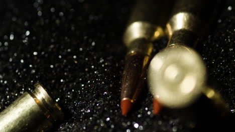 6mm-Advanced-Rifle-Cartridges-On-Heap-Of-Bullet-Grains,-closeup,-slow-motion