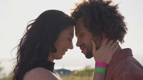cabeza y hombros cerca de una joven pareja romántica abrazándose en el campo con la puesta de sol
