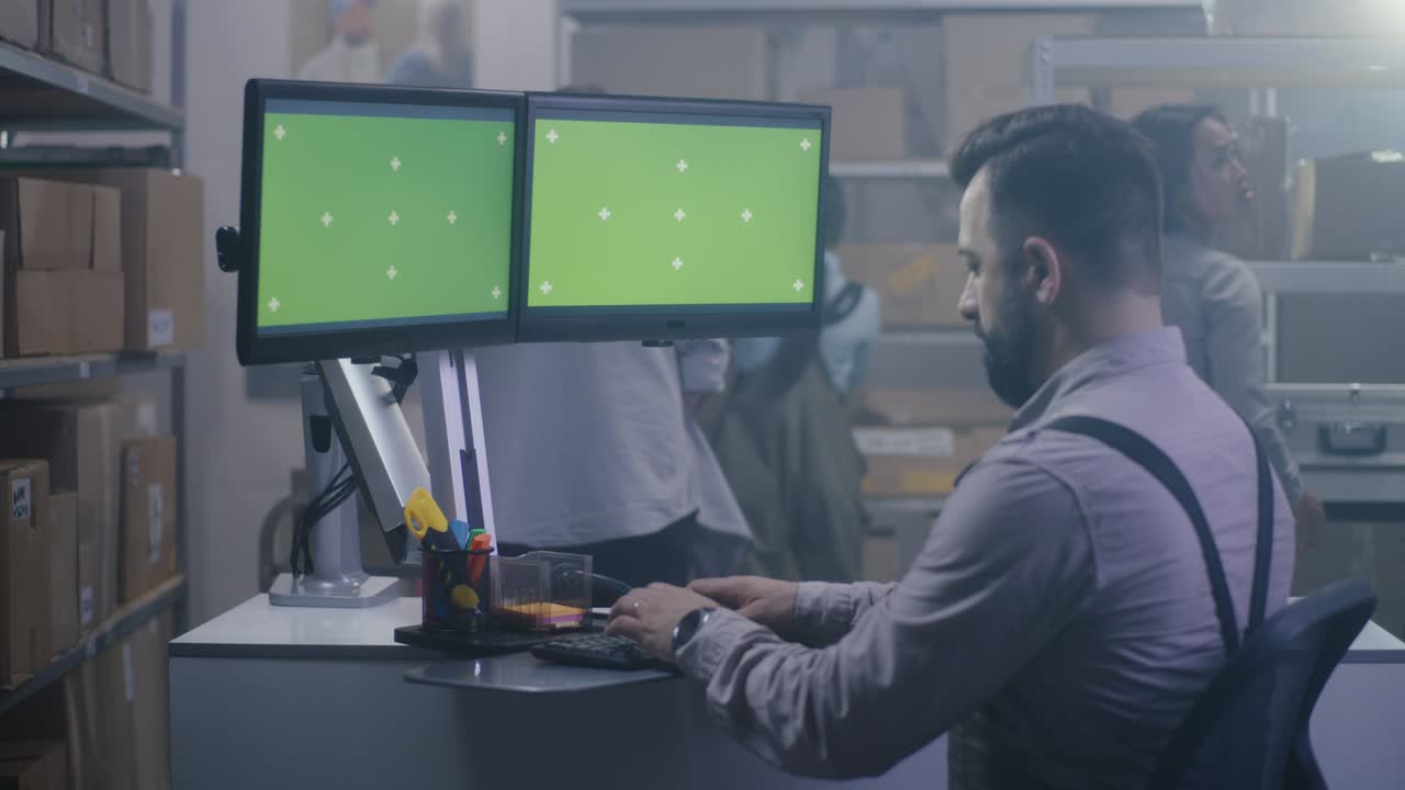 hombre trabajando en una computadora en un centro de distribución
