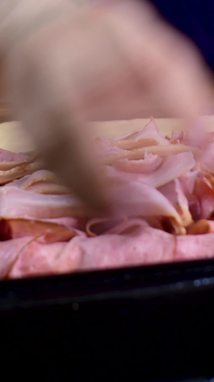 Primo piano estremo che aggiunge pancetta a prosciutto e impasto per pan de jamon