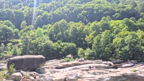 a scenic view of lavertezzo in the verzasca valley on a sunny day with people gathering around the water.