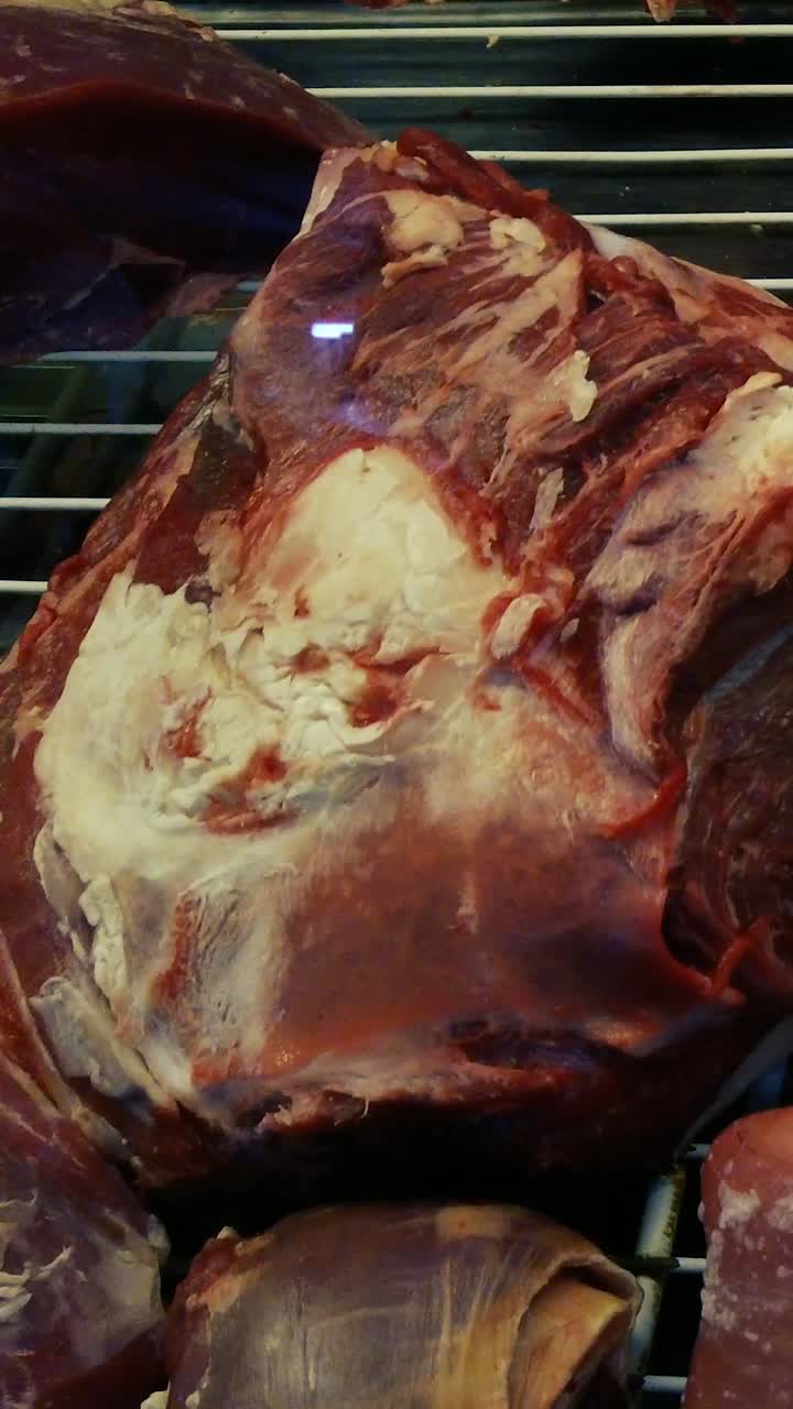 Vertical view of red meat raw displayed in Argentine Asado butcher shop, closeup