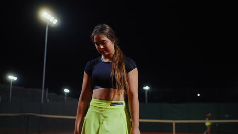 woman playing tennis at night