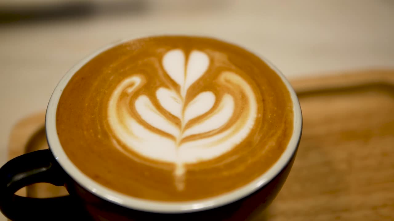 위에 라떼 아트가 있는 커피 한 잔의 영상을 닫습니다.