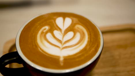 imágenes de cerca de una taza de café con arte latte en la parte superior