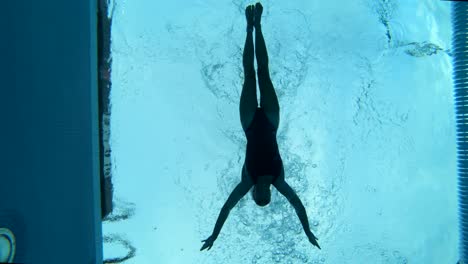 underwater shot of a female swimmer swimming smoothly in her lane of a public pool