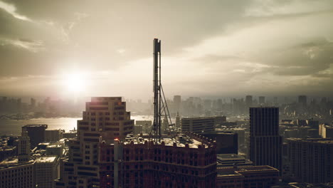 sunset over city skyline with a tower rising above modern buildings