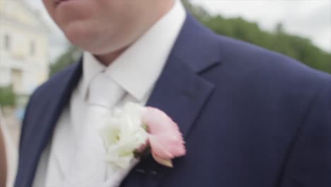 el novio en un traje con boutonniere