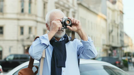 portrait of senior man with long hair standing in front of the camera and taking photos