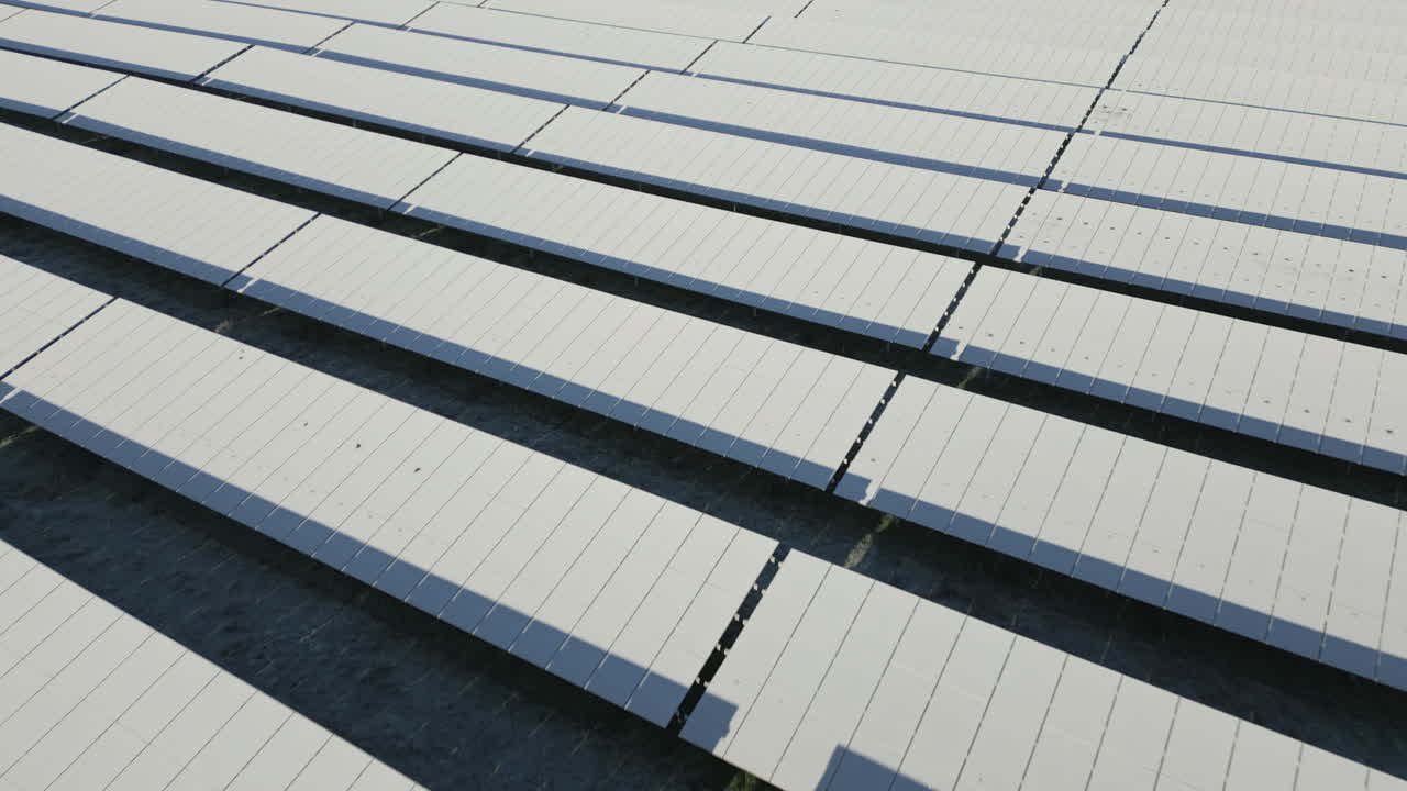 눈과 얼음으로 덮인 태양광 발전소의 태양 전지판, 낮은 드론 비행, 느린 전진