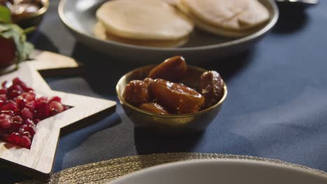 person eating dates at muslim family table at home set for iftar meal breaking daily fast during ramadan 1