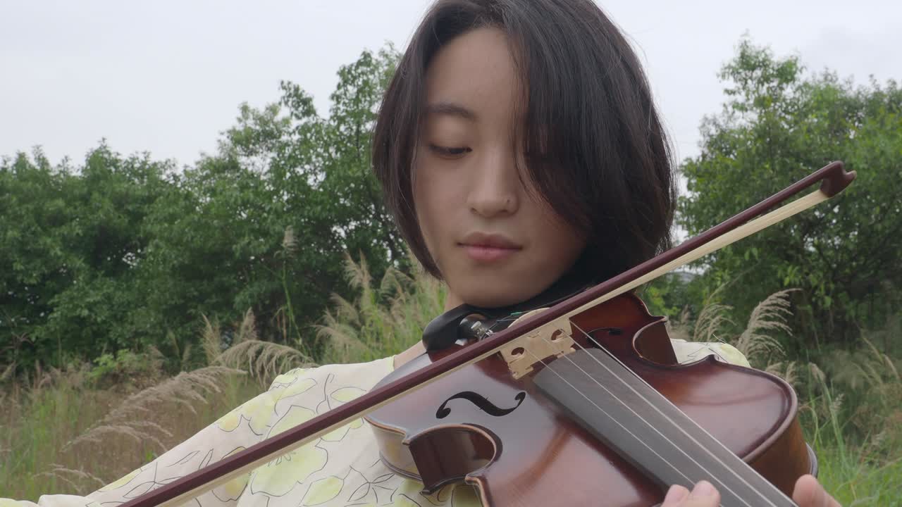 바이올린을 연주하는 아시아 십대 여성