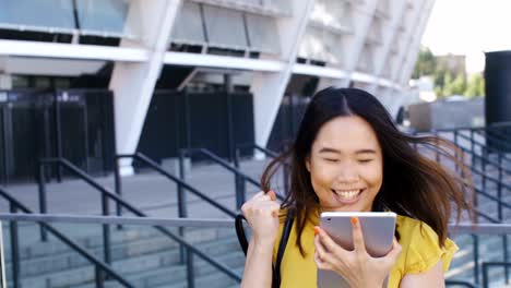 mujer de negocios asiática saltando feliz con el touchpad