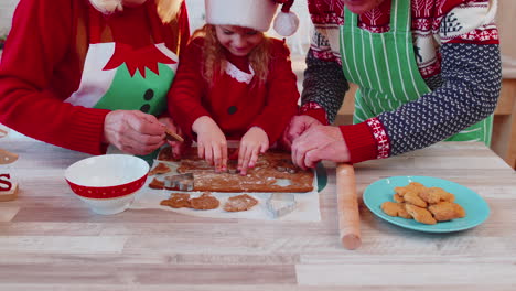 Senior-old-grandparents-with-grandchild-girl-kid-preparing,-cooking-cookie-at-home-Christmas-kitchen