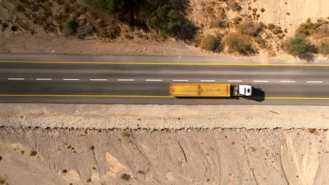 Car-zooming-by-heading-north-on-a-Desert-highway-with-cloudy-blue-sky