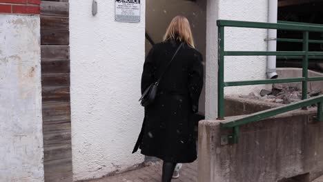 young beautiful blonde women walking into a parking lot during a light snowfall during the winter months in canada