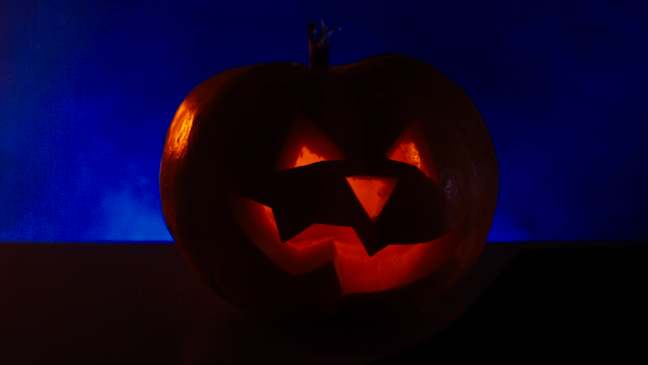 cinemagraph - cu halloween tallado calabaza jack-o-lanterna con velas, niebla en el fondo