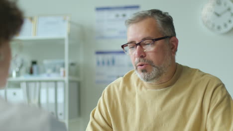 Mid-Aged Patient Having Discussion with Doctor during Medical Appointment