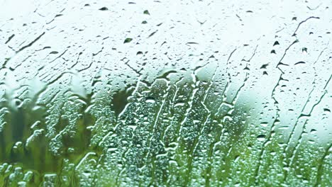 raindrops trickle down glass, blurring scenic view