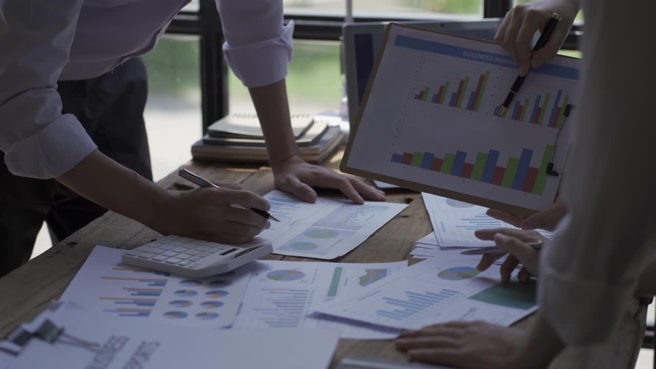 Happy Asian Business Woman Team Meeting Brainstorm Coworkers Project Finance Graph Document Work Together Strategic Planning For Success Enjoy working as a team in the office.