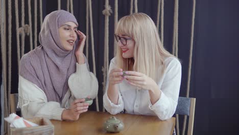 two women friends enjoying tea in a cafe