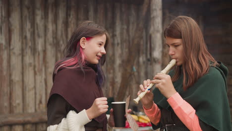 Couple-of-girls-in-medieval-costumes-learn-to-play-flute