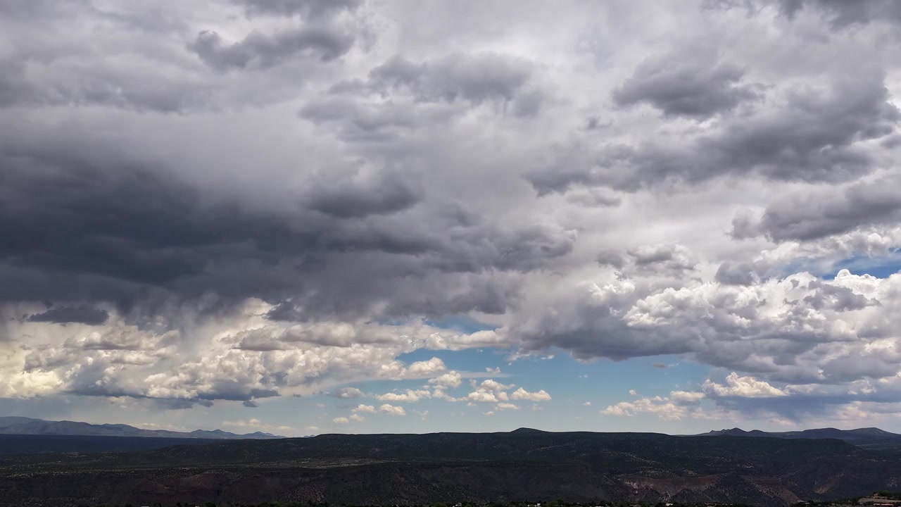 Un timelapse 4K con drone cattura il movimento caotico delle nuvole e una tempesta che si sta formando contemporaneamente. Il movimento aereo cinematografico rivela condizioni meteorologiche altamente dinamiche e turbolente su un aspro panorama desertico del sud-ovest.