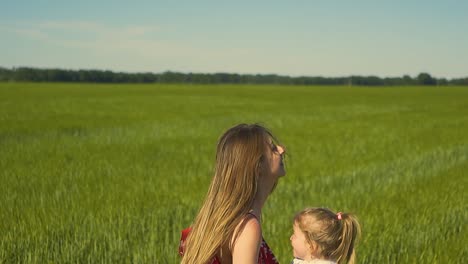 Close-up-Slow-motion-Young-mother-throws-little-daughter-in-her-arms-Smiling