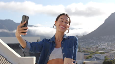 smiling woman using smartphone on balcony with scenic mountain view, copy space