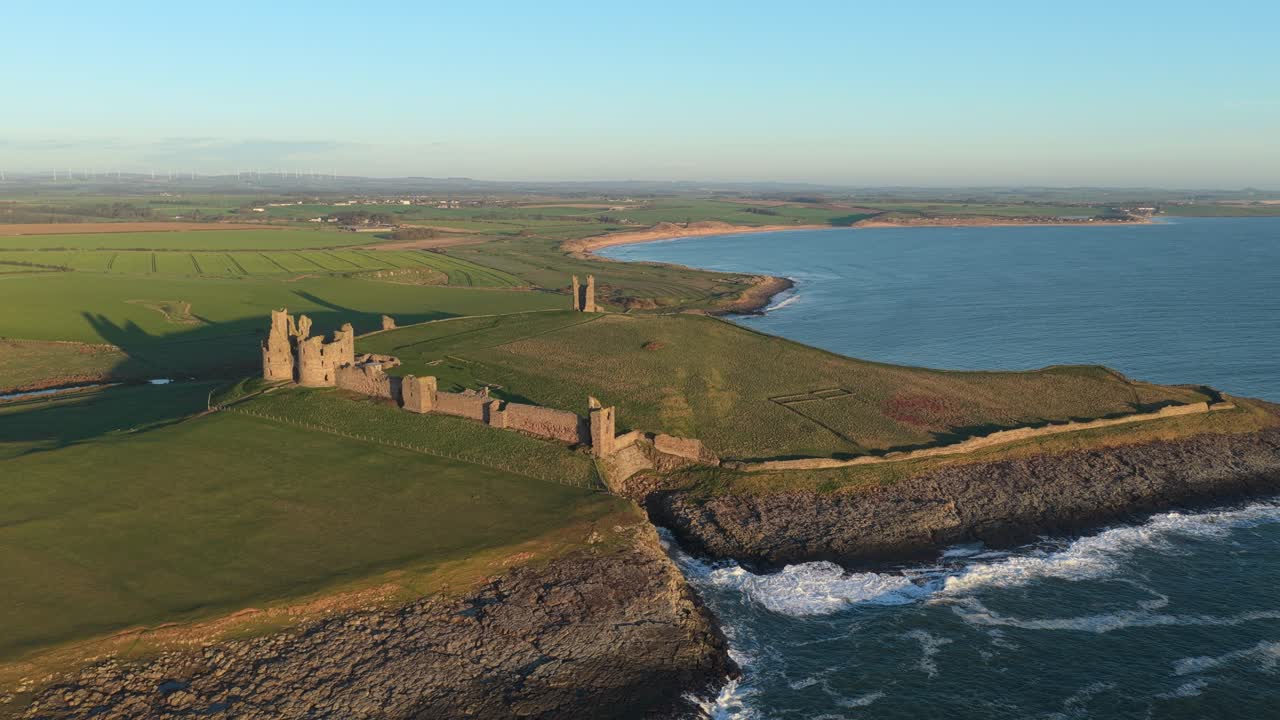 Dunstanburgh slotsruiner, luftfoto ved solopgang