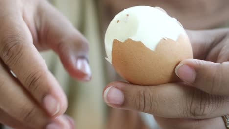 person peeling a boiled egg