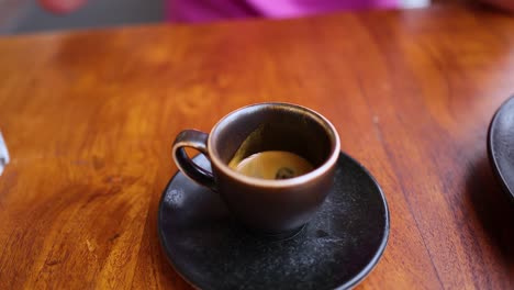 la mano coloca la taza de espresso en el platillo