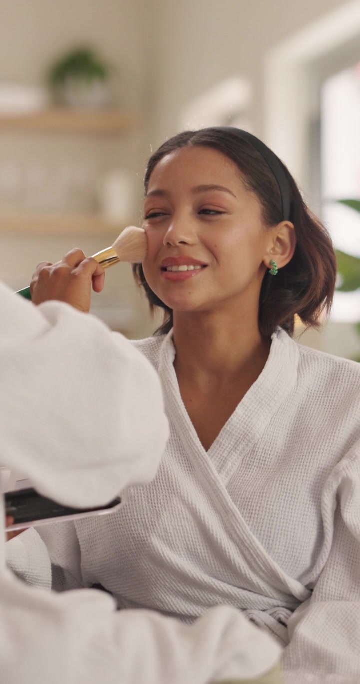 Makeup Artist Applying Powder to Young Woman in Spa