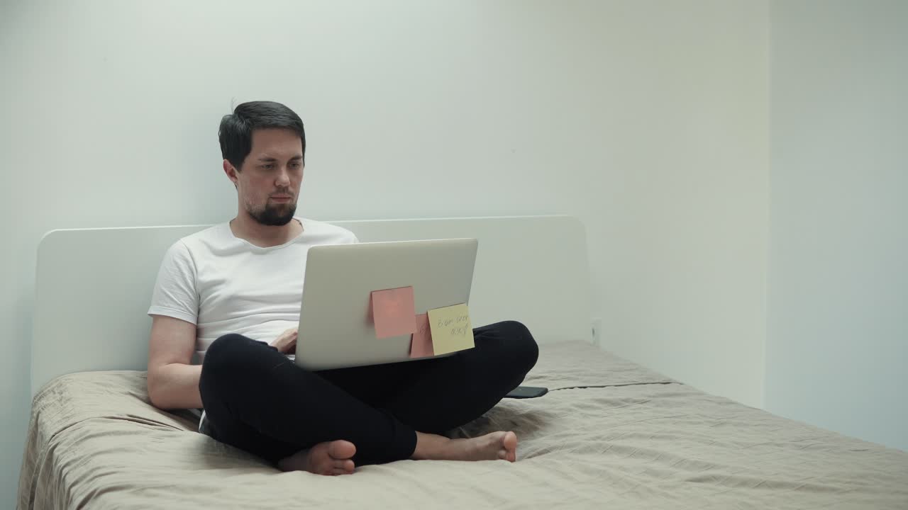 hombre trabajando en la computadora portátil en la cama