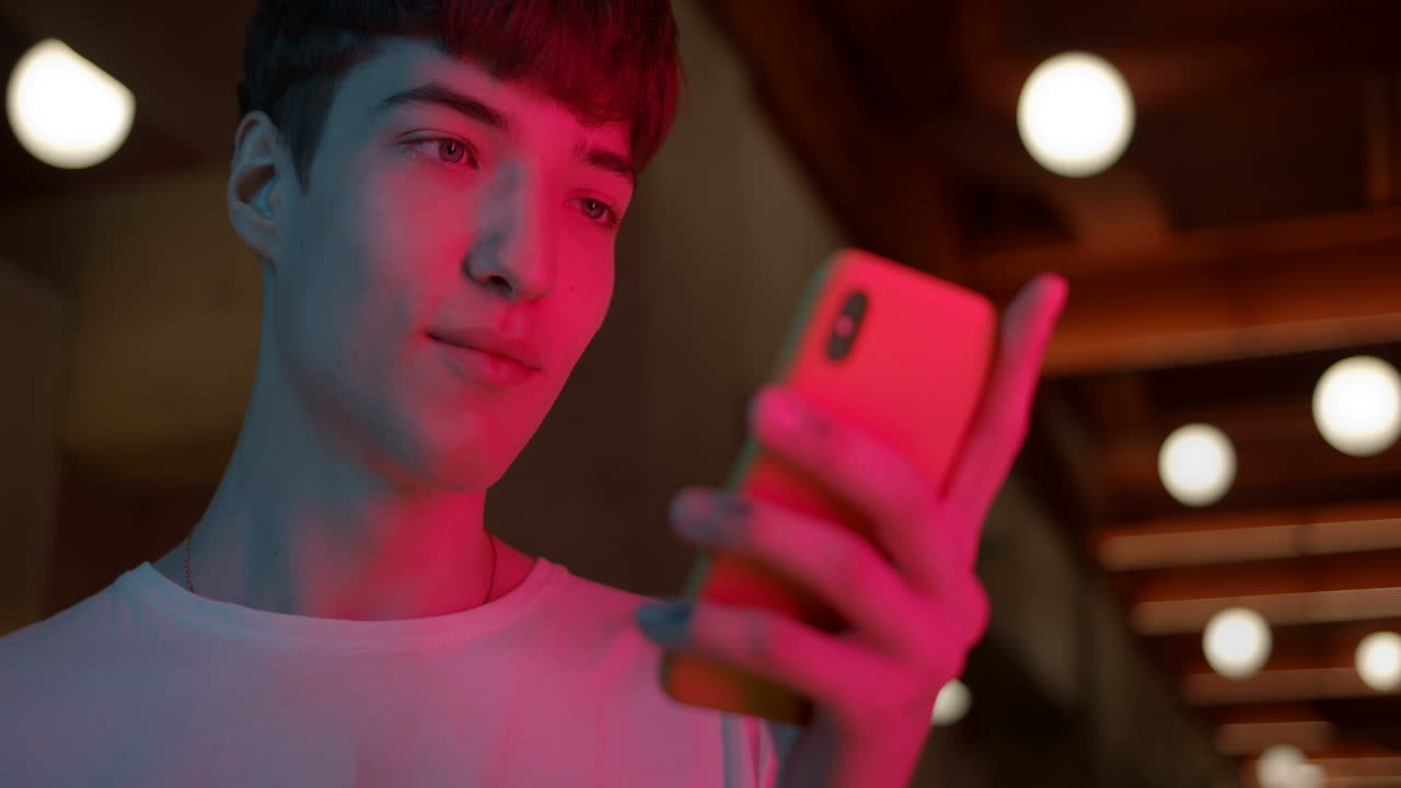 밤에 스마트폰을 사용하는 젊은 남자