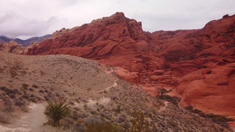 Gimbal-close-up-panning-shot-of-the-hiking-trails-towards-rugged-sandstone-rocks-in-Red-Rock-Canyon,-Nevada