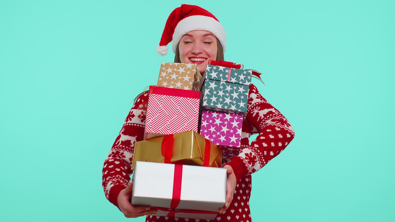 Girl in christmas red sweater santa hat smiling holding many gift boxes new year presents shopping